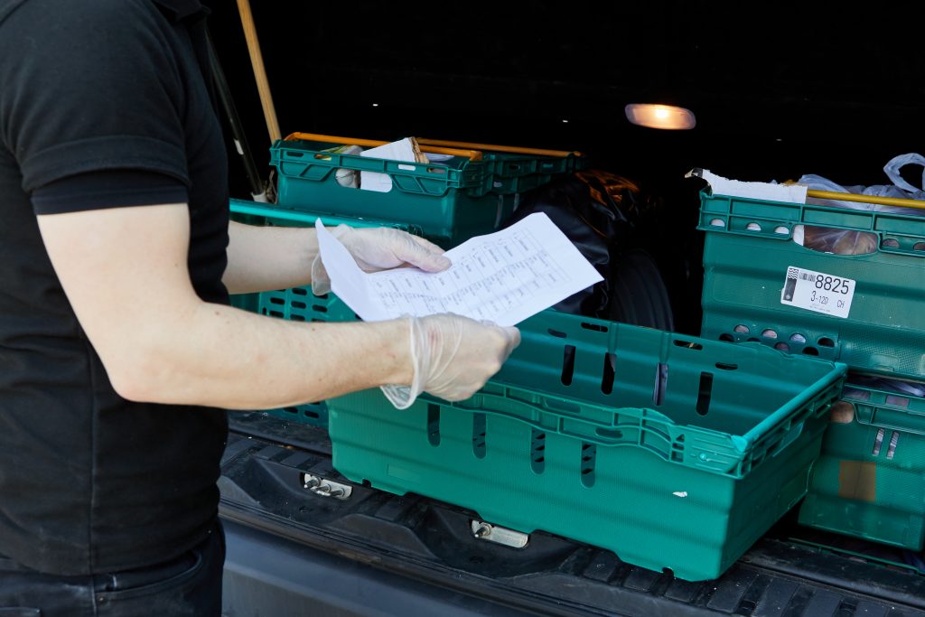 Hands with paper next to crates