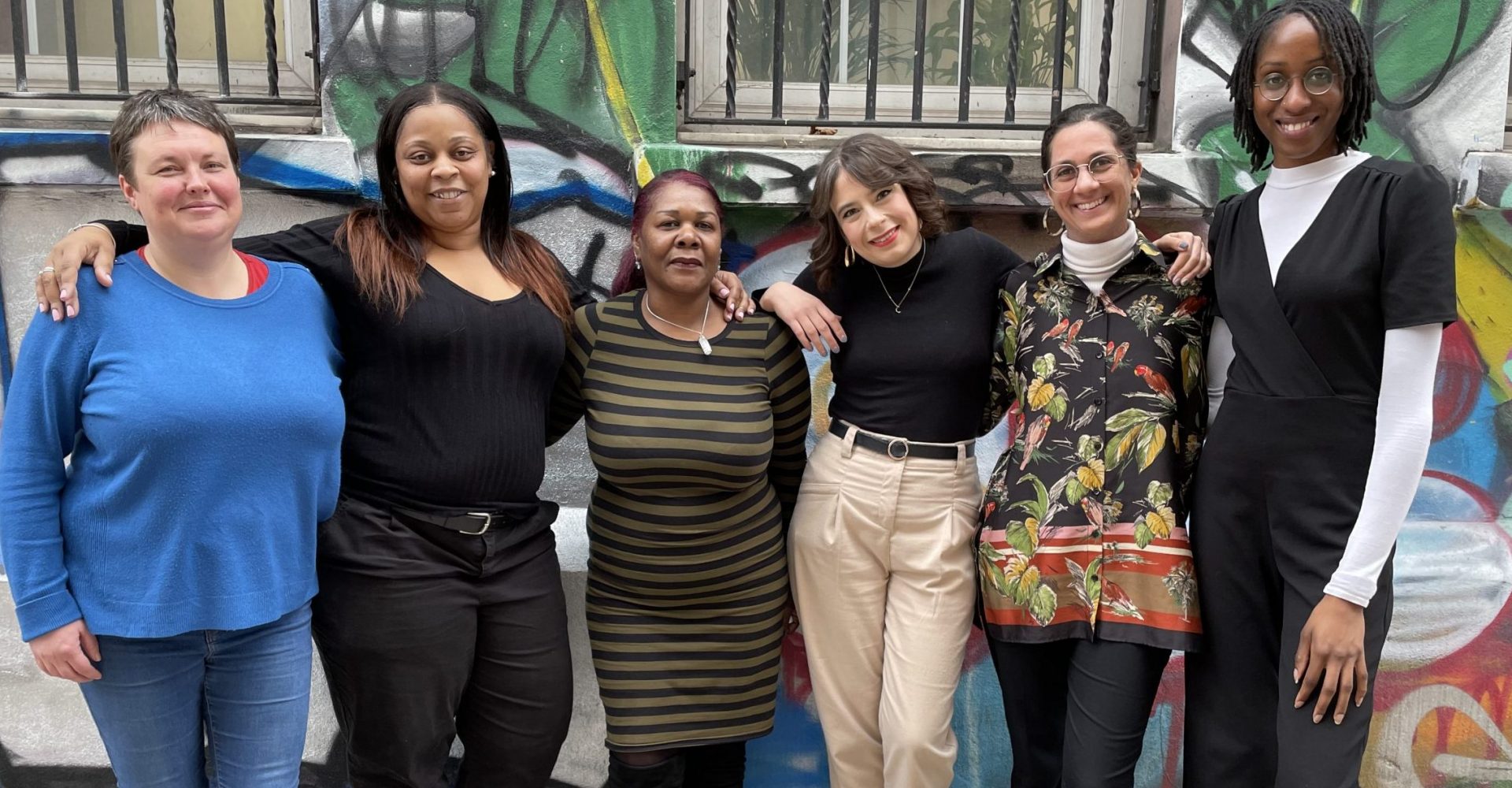 Women standing against a wall