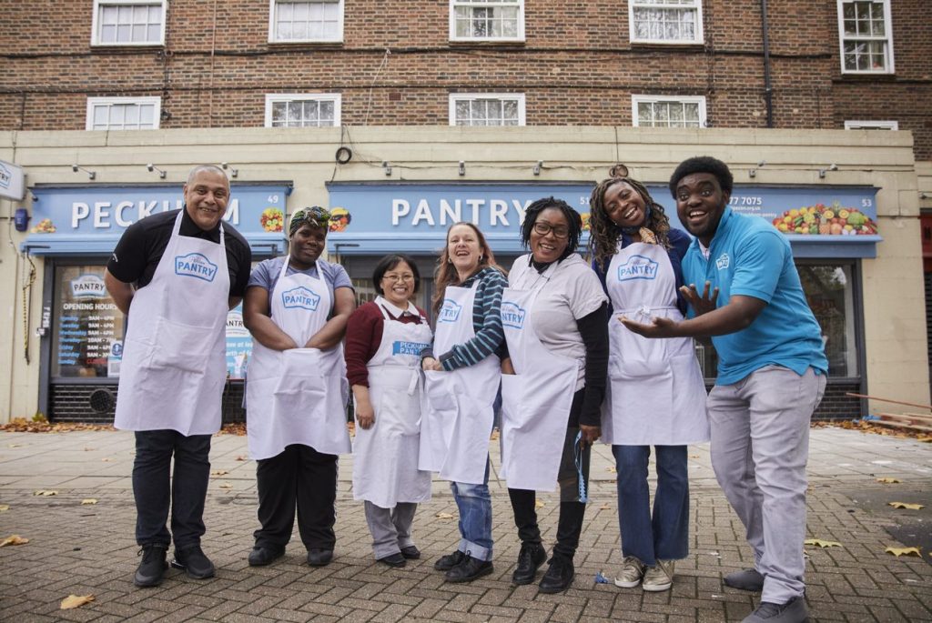 A group of pantry workers smiling outside of the shop