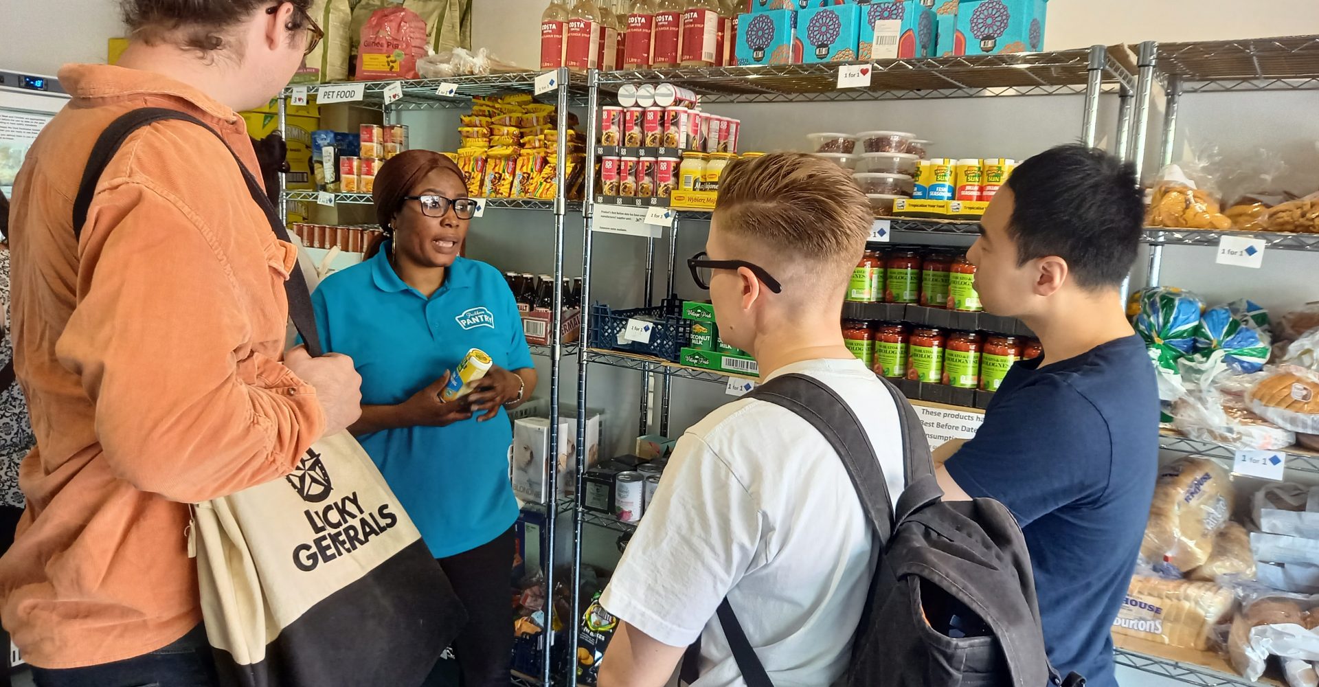 A group of people listening to a woman talk in a shop